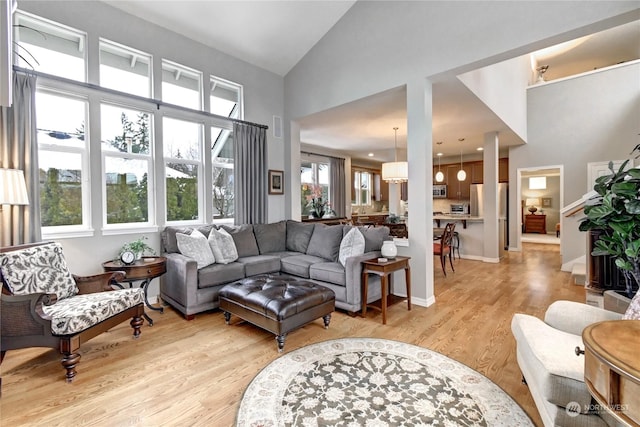 living room featuring light hardwood / wood-style flooring and high vaulted ceiling