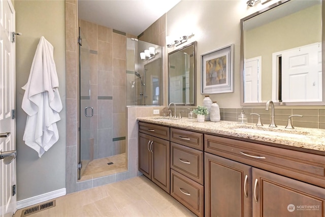 bathroom featuring tile patterned flooring, vanity, and an enclosed shower