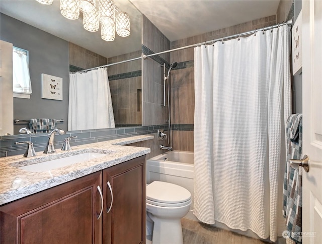 full bathroom featuring shower / bathtub combination with curtain, vanity, toilet, and a chandelier