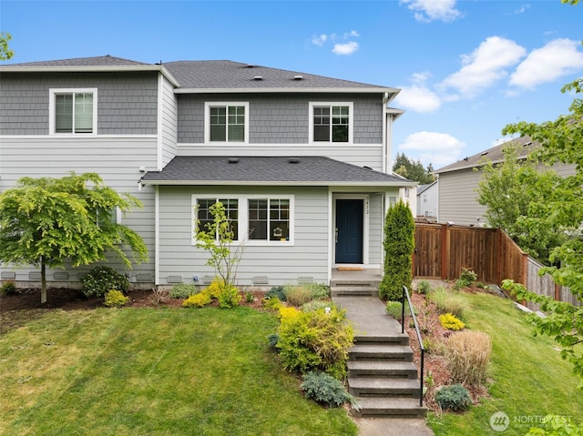 back of property featuring fence, a yard, and roof with shingles