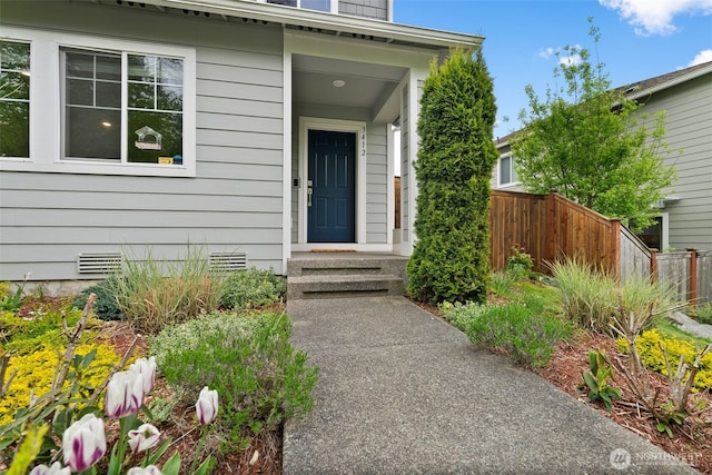 view of exterior entry featuring fence