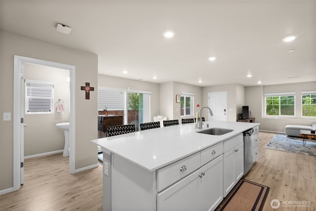 kitchen with a sink, light wood-style flooring, a wealth of natural light, and open floor plan