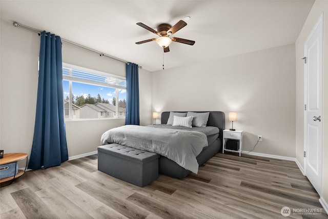bedroom featuring a ceiling fan, baseboards, and wood finished floors