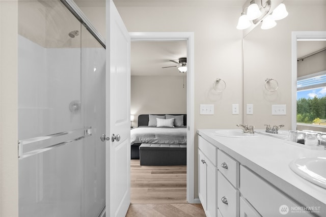 full bathroom with connected bathroom, ceiling fan, a sink, double vanity, and a shower stall
