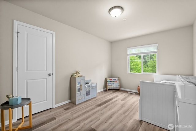 laundry area featuring baseboards and light wood-style floors