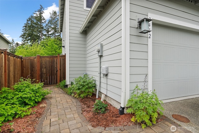 view of side of home with a garage and fence