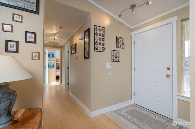 entryway with crown molding and light wood-type flooring