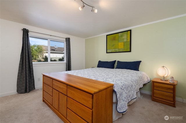 carpeted bedroom featuring rail lighting