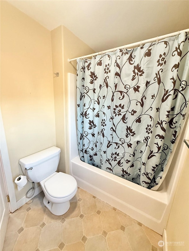 bathroom featuring tile patterned flooring, shower / tub combo, and toilet