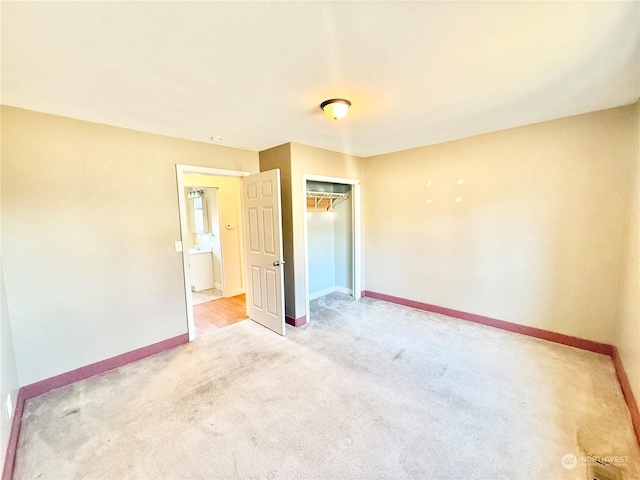 unfurnished bedroom with light carpet and a closet