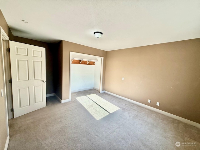 unfurnished bedroom with light colored carpet and a closet