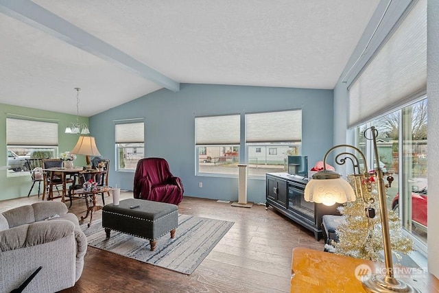 living room featuring hardwood / wood-style flooring, a textured ceiling, and vaulted ceiling with beams