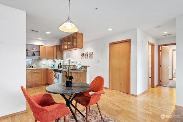 dining room featuring sink and light wood-type flooring