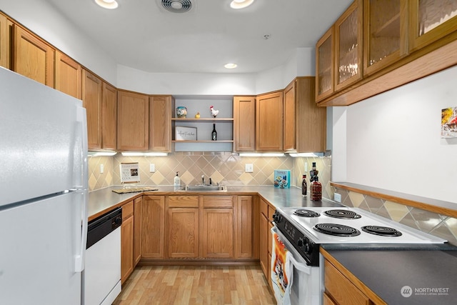 kitchen featuring sink, white appliances, light hardwood / wood-style flooring, and decorative backsplash