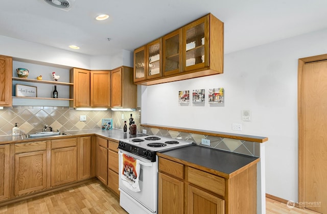 kitchen with sink, light hardwood / wood-style flooring, white range with electric stovetop, and decorative backsplash