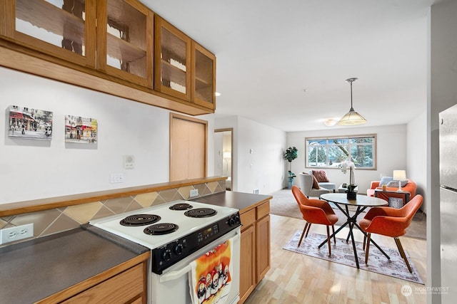 kitchen featuring pendant lighting, white range with electric cooktop, and light hardwood / wood-style flooring