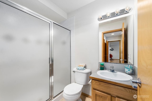 bathroom featuring vanity, toilet, and an enclosed shower