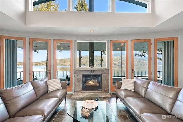 living room with a water view, a wealth of natural light, and a high ceiling