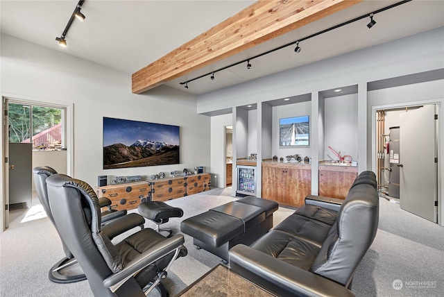 cinema room featuring carpet, rail lighting, and beam ceiling