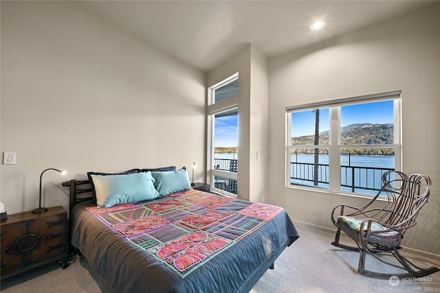 bedroom with a water view, access to exterior, and carpet floors
