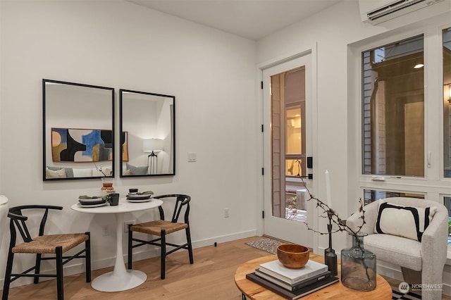 office area with a wall mounted air conditioner and light hardwood / wood-style floors