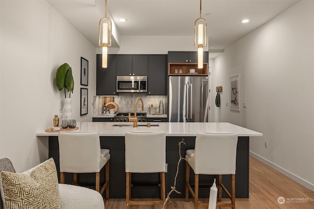 kitchen with pendant lighting, a breakfast bar area, kitchen peninsula, and appliances with stainless steel finishes