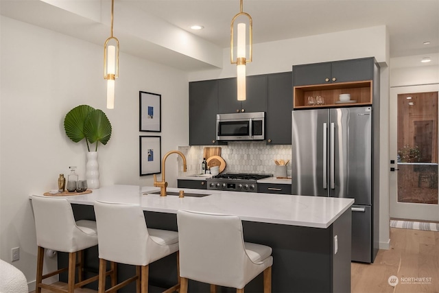 kitchen with sink, a breakfast bar area, stainless steel appliances, decorative backsplash, and kitchen peninsula