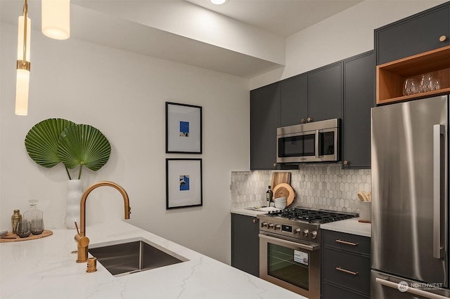 kitchen with appliances with stainless steel finishes, sink, decorative backsplash, hanging light fixtures, and light stone countertops