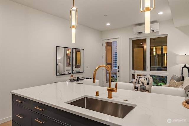 kitchen with pendant lighting, a wall mounted air conditioner, light stone countertops, and sink