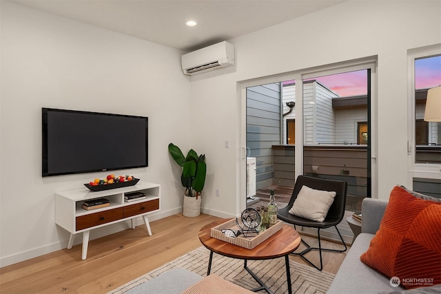 living room with a wall mounted air conditioner and light wood-type flooring