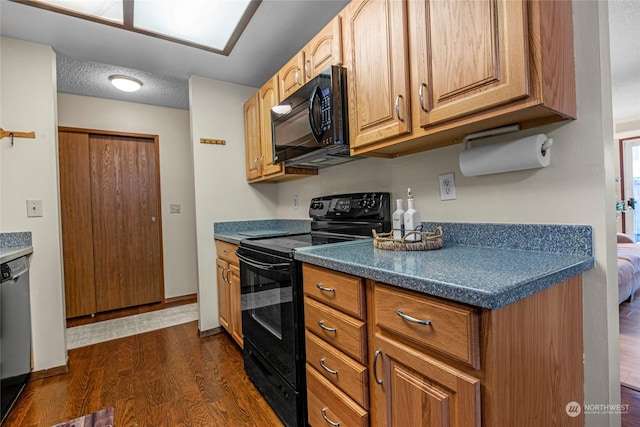 kitchen featuring black appliances, dark hardwood / wood-style floors, and a textured ceiling