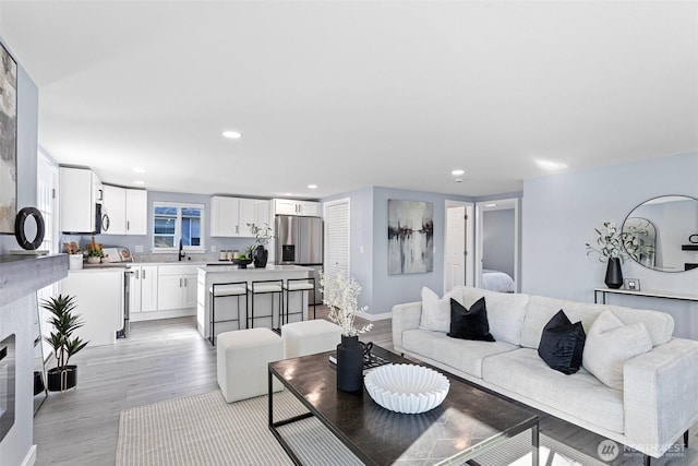 living room with sink and light hardwood / wood-style floors