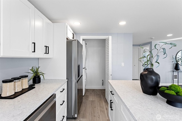 kitchen with white cabinetry, stainless steel appliances, and light hardwood / wood-style flooring