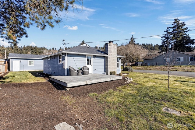 back of property with a wooden deck and a yard