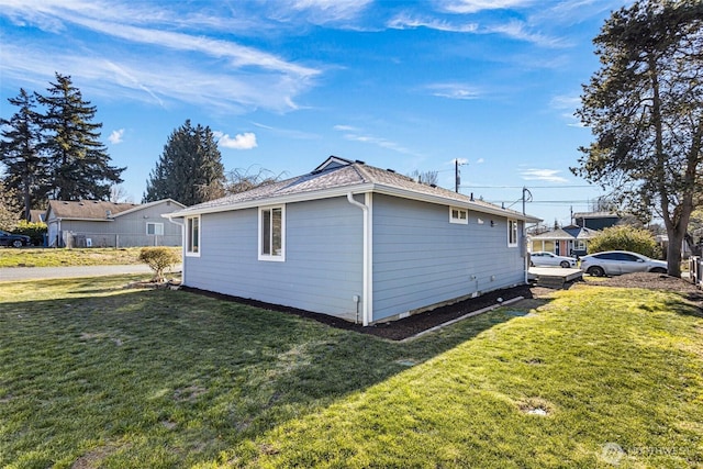 view of side of home with a yard