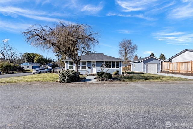 single story home featuring a garage, an outdoor structure, and a front lawn