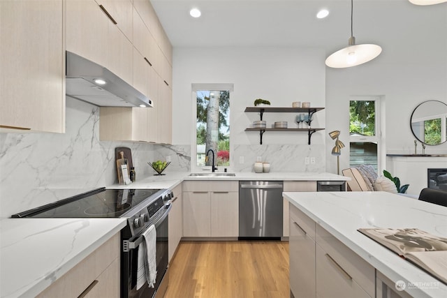 kitchen with pendant lighting, sink, appliances with stainless steel finishes, tasteful backsplash, and extractor fan