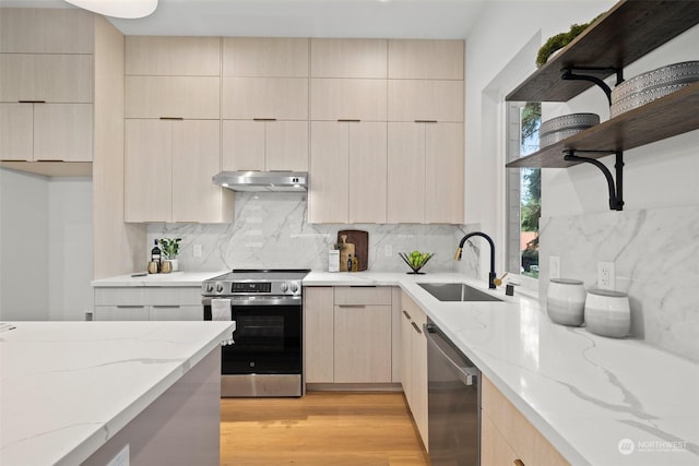 kitchen featuring appliances with stainless steel finishes, light brown cabinetry, light stone countertops, and sink