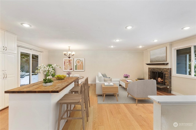 interior space featuring wood counters, hanging light fixtures, white cabinets, and light wood-type flooring