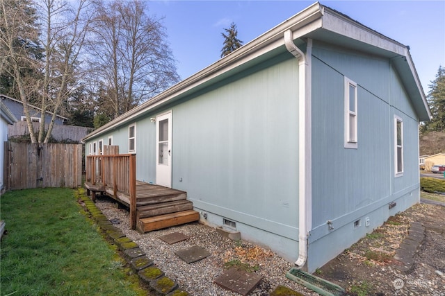 view of property exterior featuring a wooden deck and a yard