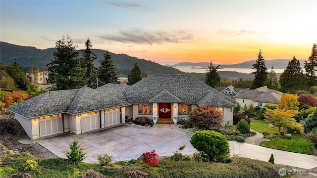 view of front of home with a garage, a mountain view, driveway, and stucco siding