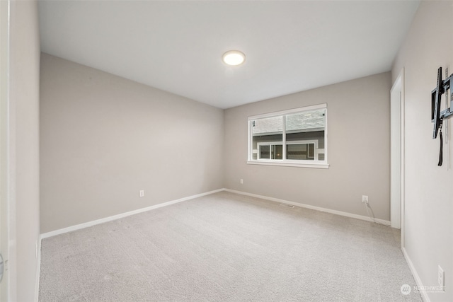 unfurnished room featuring light carpet