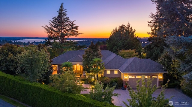 view of front of house featuring concrete driveway, a water view, and an attached garage