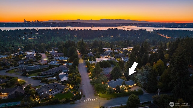 aerial view at dusk featuring a water view