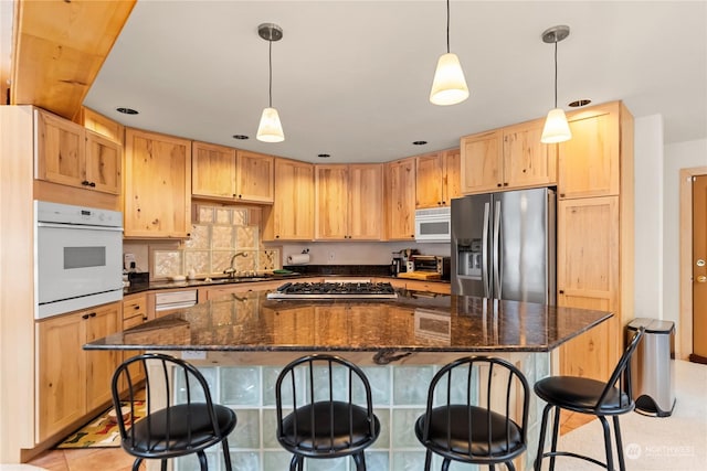 kitchen with stainless steel appliances, a center island, and decorative light fixtures