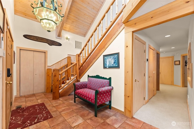 interior space with beamed ceiling, wooden ceiling, a chandelier, and a high ceiling