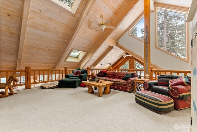 carpeted living room featuring beam ceiling, a skylight, and plenty of natural light