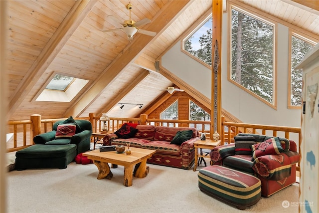 carpeted living room featuring plenty of natural light, vaulted ceiling with skylight, wooden ceiling, and ceiling fan