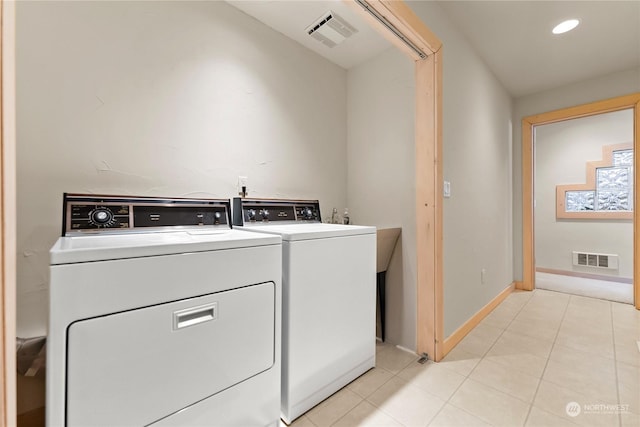 laundry area featuring independent washer and dryer and light tile patterned floors