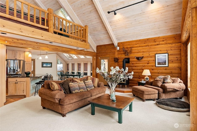 carpeted living room featuring rail lighting, wood ceiling, high vaulted ceiling, a wood stove, and beam ceiling